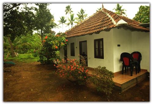 una casa con sillas sentadas en el porche. en Munroe Inn Homestay en Kollam