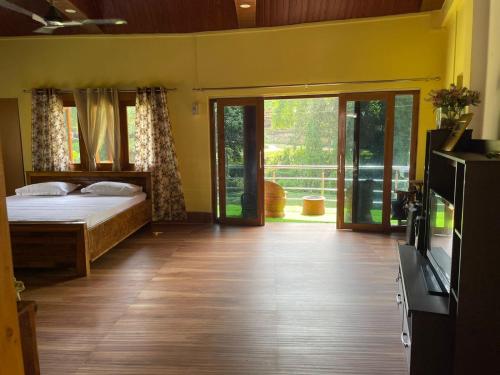 een slaapkamer met een bed en glazen schuifdeuren bij Lake Vista Home Stay in Tezpur
