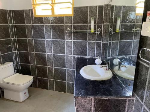 een badkamer met een toilet en 2 wastafels. bij Lake Vista Home Stay in Tezpur