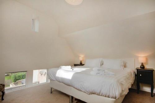 a white bedroom with a large bed with white sheets at The Old Concert Room in Alnmouth