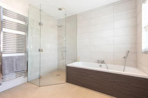 W łazience znajduje się wanna i przeszklony prysznic. w obiekcie Meadow View w mieście Alnwick
