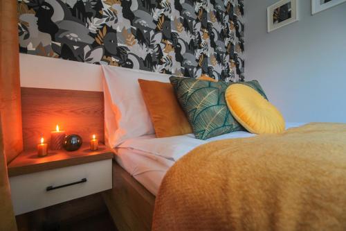 a bedroom with a bed and two candles on a night stand at Apartamenty KAPRYS - Centrum in Krynica Zdrój