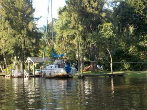 a boat is docked at a dock on the water at Cabañas ICh in Tigre