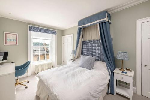a bedroom with a bed with a blue canopy at Dunsford House - Elegant Townhouse with Parking in Bath