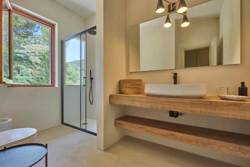 bagno con lavandino e specchio di Villa Elle Exclusive Isola d'Elba a Capoliveri