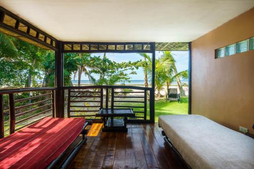a bedroom with a bed and a view of the ocean at Charisma Beach Resort in Siquijor