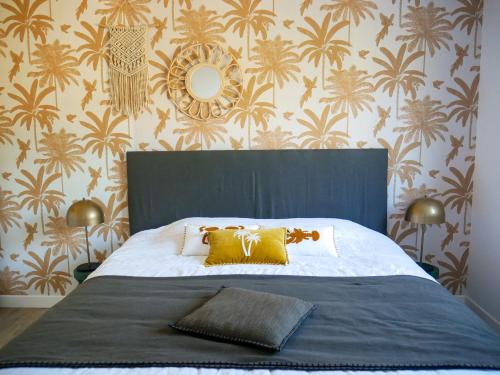 een slaapkamer met een groot bed met gele kussens en behang bij La Source - gîte en Drôme provençale - Allan in Allan
