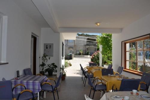 un restaurante con mesas y sillas y un patio en Room in Lopar with terrace, air conditioning, WiFi 3719-4 en Lopar