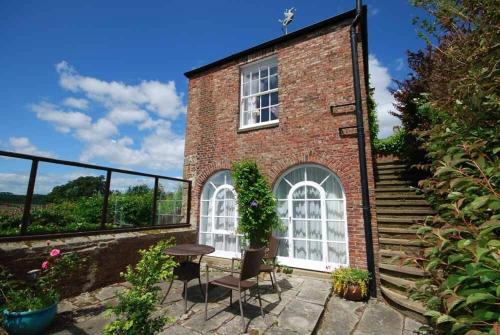 a brick building with a table and a window at The Old Watchtower in Alnmouth