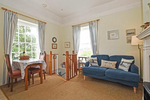 a living room with a blue couch and a table at The Old Watchtower in Alnmouth