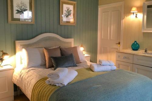 a bedroom with a large bed with towels on it at The Old Watchtower in Alnmouth