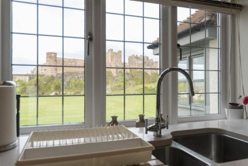 een keuken met een wastafel en een groot raam bij Keeper's View in Bamburgh