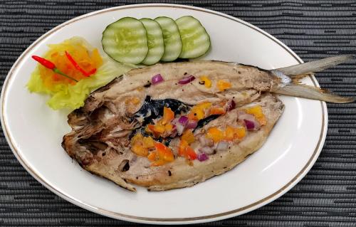a plate of food with a piece of meat and vegetables at Sulu Sunset Beach Resort in Nauhang