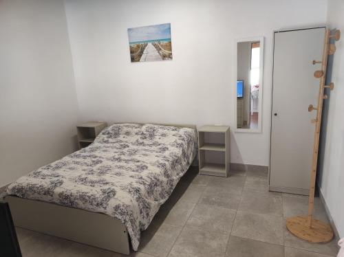 een kleine slaapkamer met een bed en een spiegel bij Casita La Gomera in San Sebastián de la Gomera