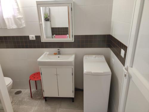 ein Badezimmer mit einem Waschbecken, einem WC und einem Spiegel in der Unterkunft Casita La Gomera in San Sebastián de la Gomera