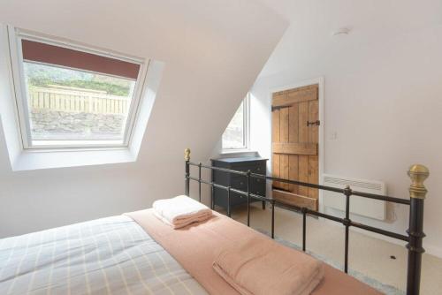 a bedroom with a bed and a window in it at Seal Cottage in Burnmouth