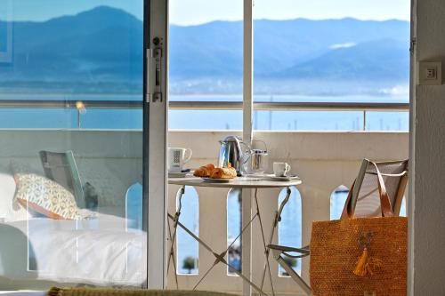 - une table sur un balcon avec vue sur l'océan dans l'établissement Hôtel Du Golfe, à Ajaccio