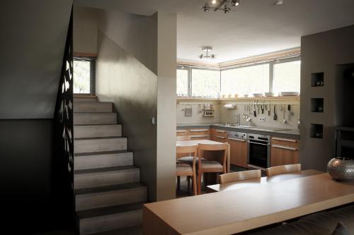 eine Küche und ein Esszimmer mit einer Treppe und einem Tisch in der Unterkunft Gästehaus im Weingut am Stein in Würzburg