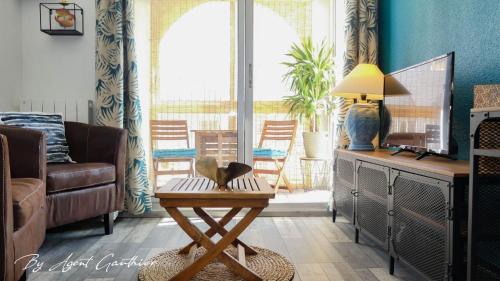 a living room with a table with a lamp on it at Charmant 2 pièces les pieds dans l'eau in Sète