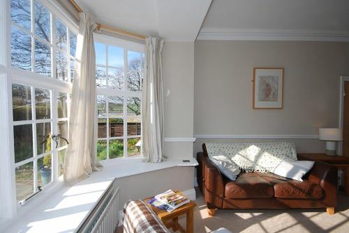 a living room with a couch and a large window at Beach House Alnmouth in Alnmouth