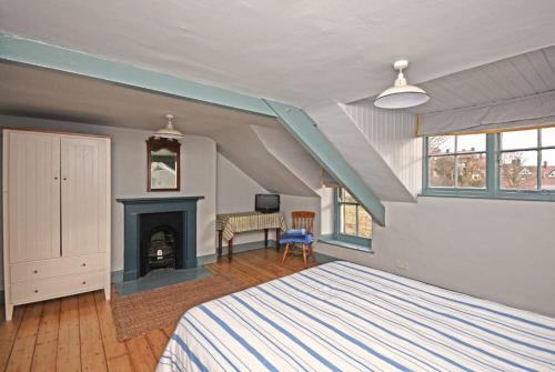 a bedroom with a bed and a fireplace at Beach House Alnmouth in Alnmouth