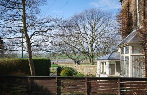 a wooden fence in front of a house at Beach House Alnmouth in Alnmouth