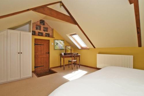 a bedroom with a bed and a desk in it at The Granary in Newton-by-the-Sea