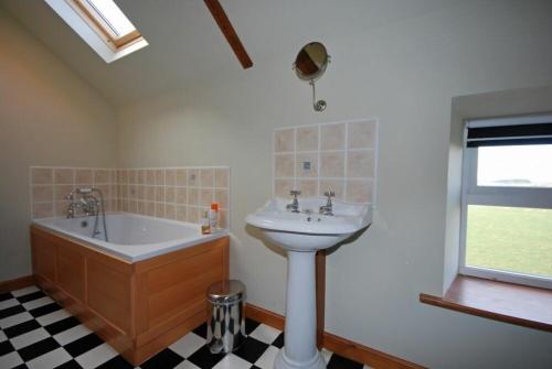 a bathroom with a sink and a bath tub and a sink at The Granary in Newton-by-the-Sea