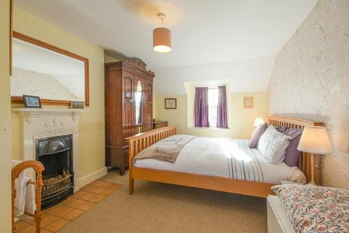 a bedroom with a large bed and a fireplace at Hilltop Cottage in Wark