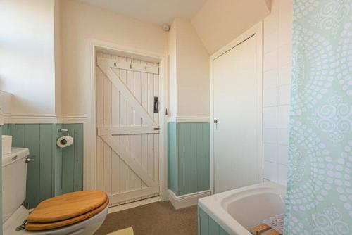 a bathroom with a wooden toilet and a shower at Hilltop Cottage in Wark