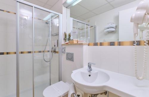 a white bathroom with a shower and a sink at Mare Mare Suites in Mali Lošinj
