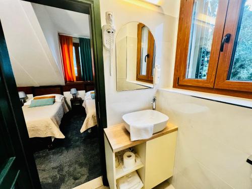 a bathroom with a sink and a mirror and a bed at Hotel Villa Diana in Split