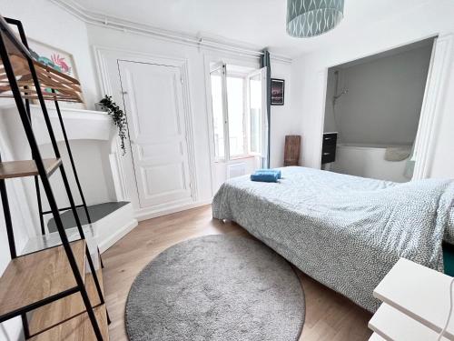 um quarto branco com uma cama e uma escada em Le Cliersou - Appartement bien situé à Clermont-Ferrand Fontgieve em Clermont-Ferrand