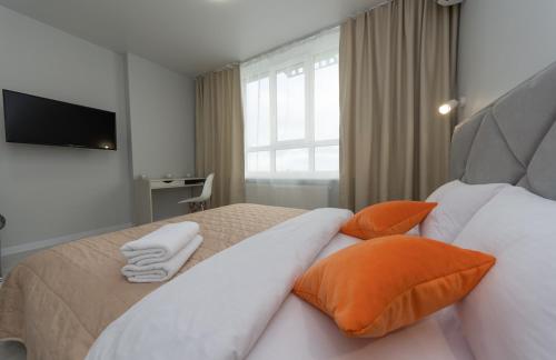 a bedroom with a bed with orange and white pillows at Люкс на Бориспільській ЖК Олімпік Парк, генератор на будинку in Kyiv
