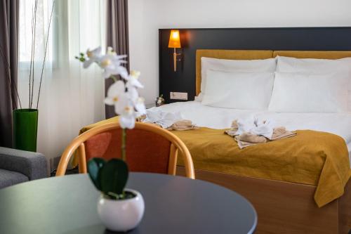a hotel room with a bed with a table and chairs at Zsóry Liget Hotel & Spa Superior in Mezőkövesd