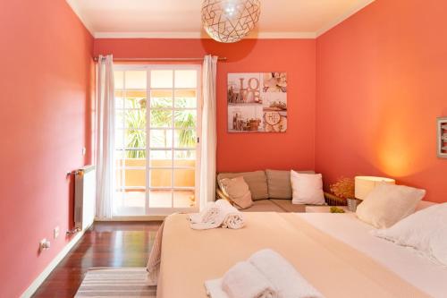 een slaapkamer met oranje muren en een groot bed bij Mare Cascais Apartment in Cascais