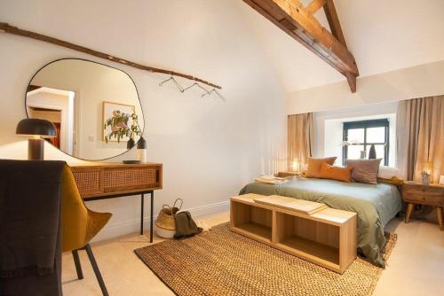 een slaapkamer met een bed, een spiegel en een bureau bij The Bolthole in Eglingham