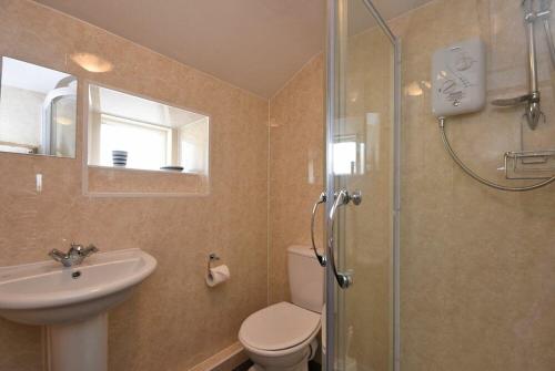 a bathroom with a toilet and a sink and a shower at Bilton Farm Cottage No1 in Alnmouth