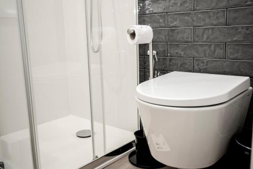 a white toilet in a bathroom with a shower at Casa de Couros in Guimarães
