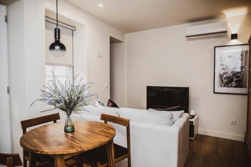 a living room with a white couch and a table at Casa de Couros in Guimarães