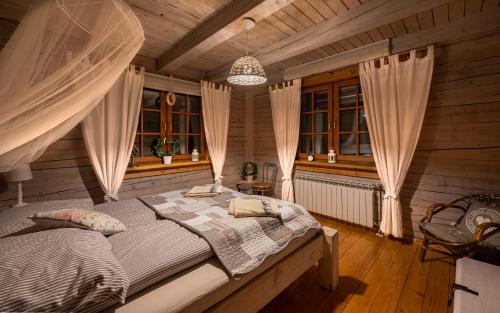 een slaapkamer met een bed in een houten kamer bij Bieszczady Chata in Malinówka