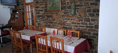 a dining room with a table and chairs and a brick wall at Casa Samarra in Vall de Cardos