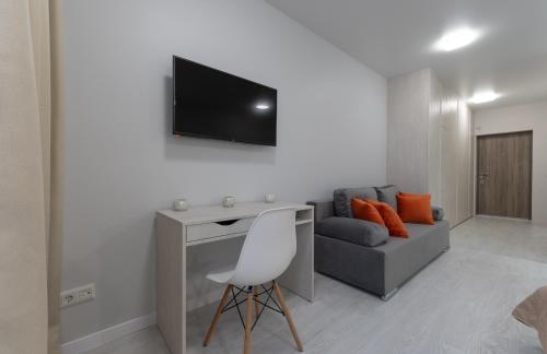 a living room with a couch and a television on a wall at Люкс на Бориспільській ЖК Олімпік Парк, генератор на будинку in Kyiv