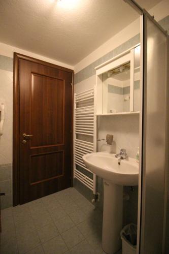 baño con lavabo y puerta de madera en Residence Aquila - Bilo Mont Nery, en Brusson