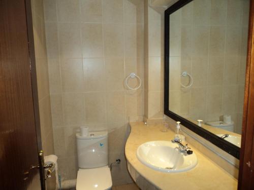 a bathroom with a toilet and a sink and a mirror at Marina Apartment Agadir in Agadir