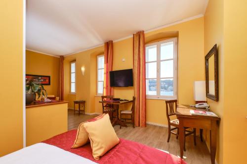 Habitación de hotel con cama, escritorio y mesa. en Mare Mare Suites en Mali Lošinj