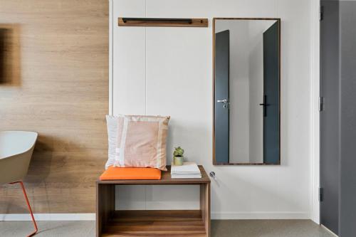 a bathroom with a bench with a mirror and a sink at Aiden by Best Western Herning in Herning