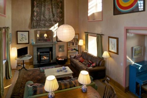 a living room with a couch and a fireplace at Kirknowe in Jedburgh