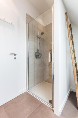 a shower with a glass door in a bathroom at La Grange in Birkenwald