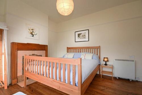 a bedroom with a wooden crib in a room at Melvin Cottage in Embleton